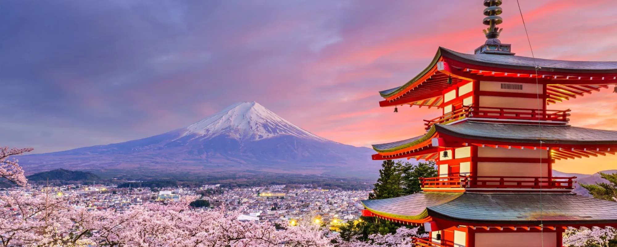 Travelers walking through a quiet temple lane in Japan at golden hour